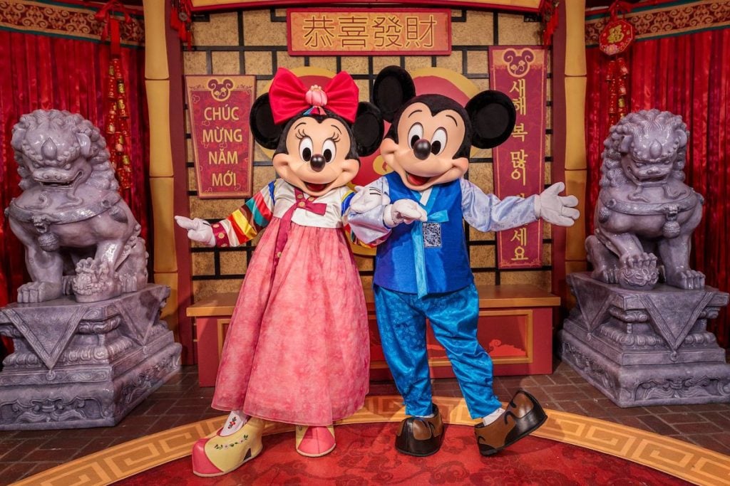 mickey mouse and minnie mouse dressed up in special event costume for lunar new year